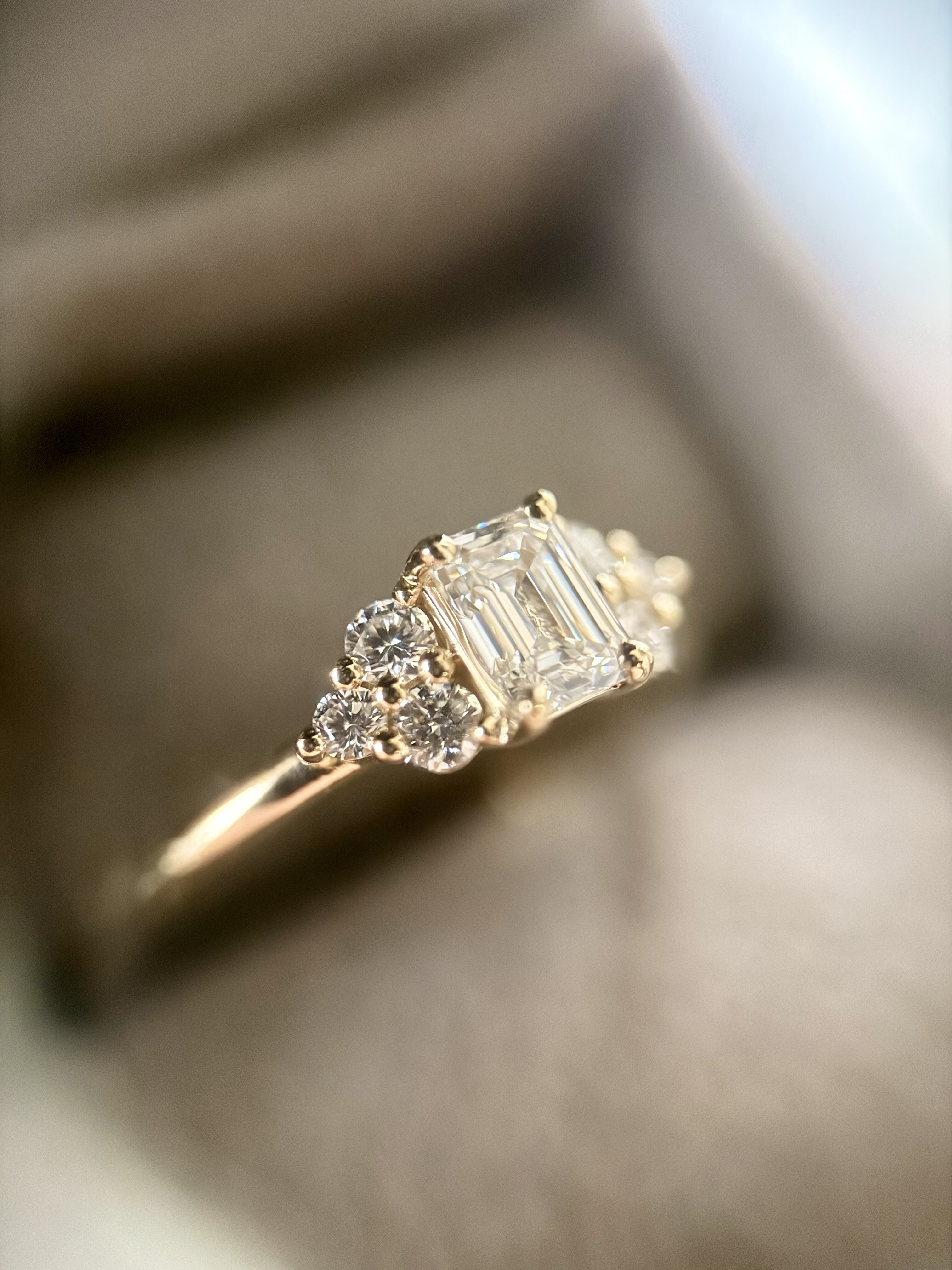 Ring med emerald cut diamant og brillanter i gulguld