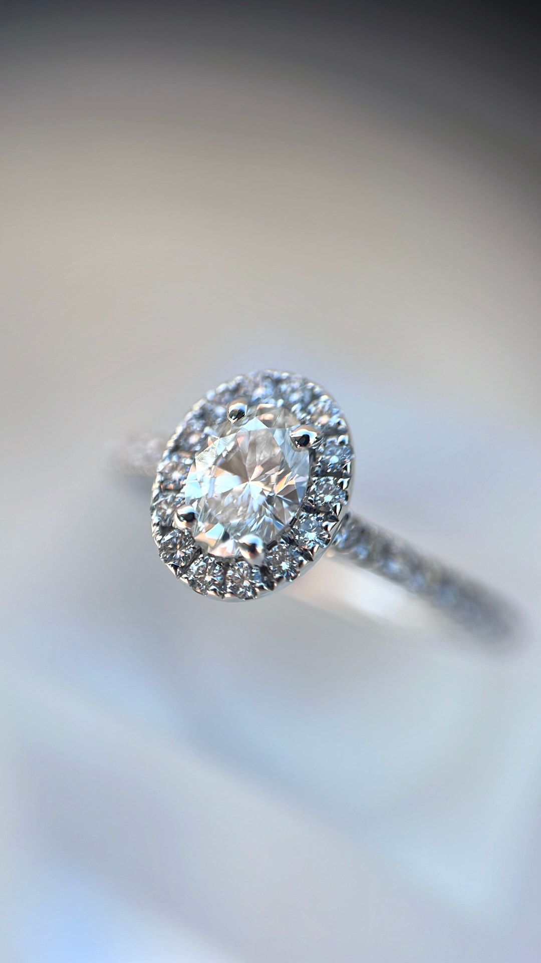 Ring med oval diamant omgivet af pavé af brillanter