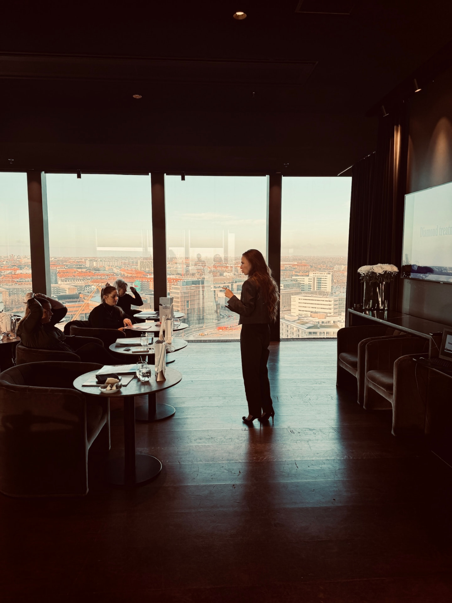 Undervisning i højhuslokale med panoramaudsigt over byen ved solnedgang
