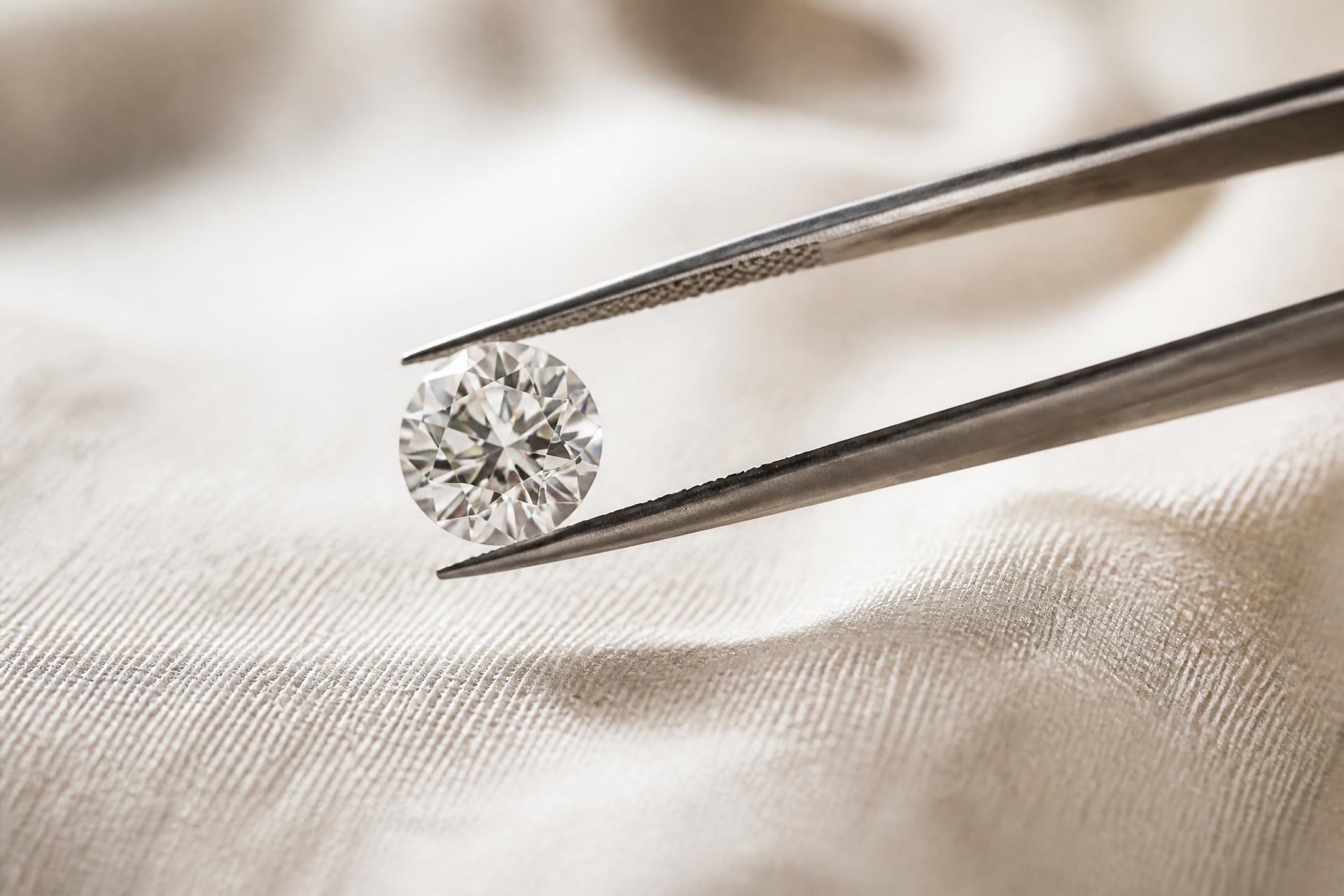 Diamantpincet der holder en løs brillantsleben diamant