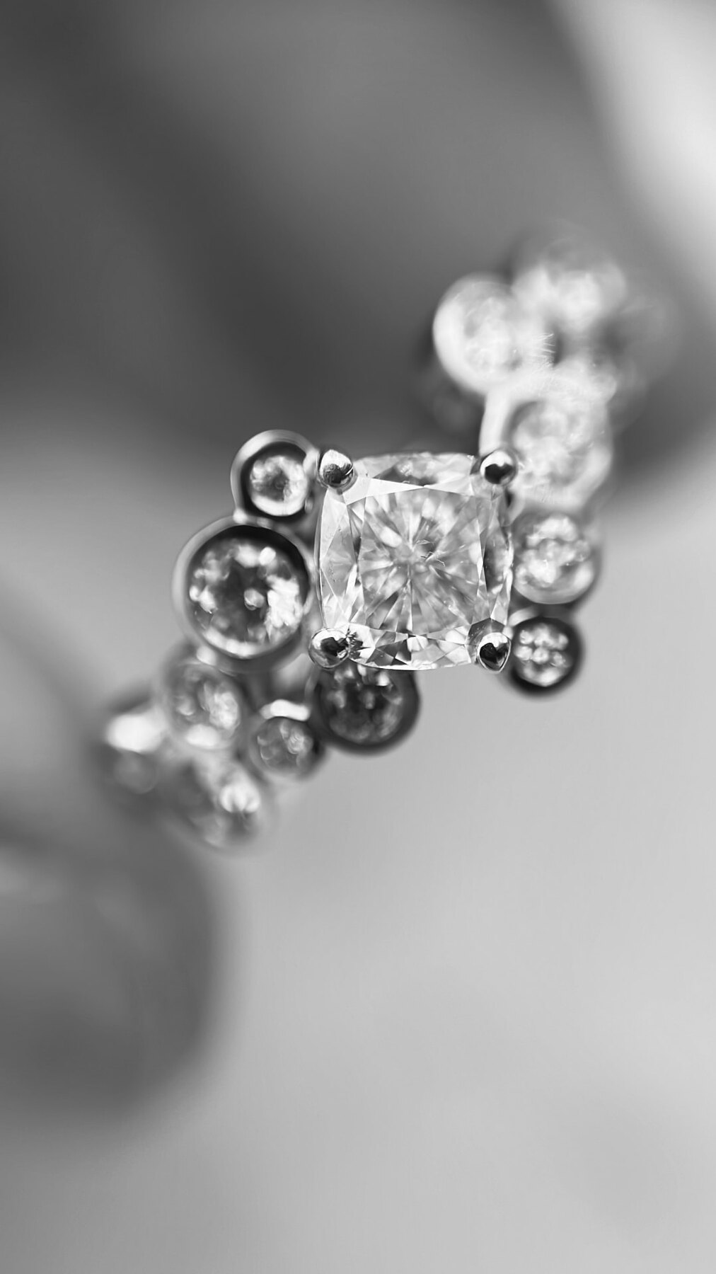 Ring med cushion cut diamant og fattede brillanter