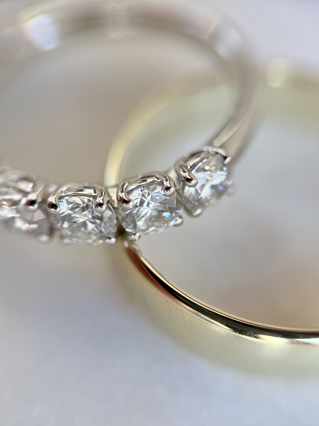 Solitairering med oval diamant og pavéfattet skinne båret på hånden